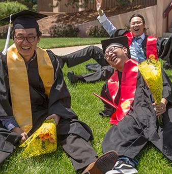 Students sitting on lawn celebrating Graduation